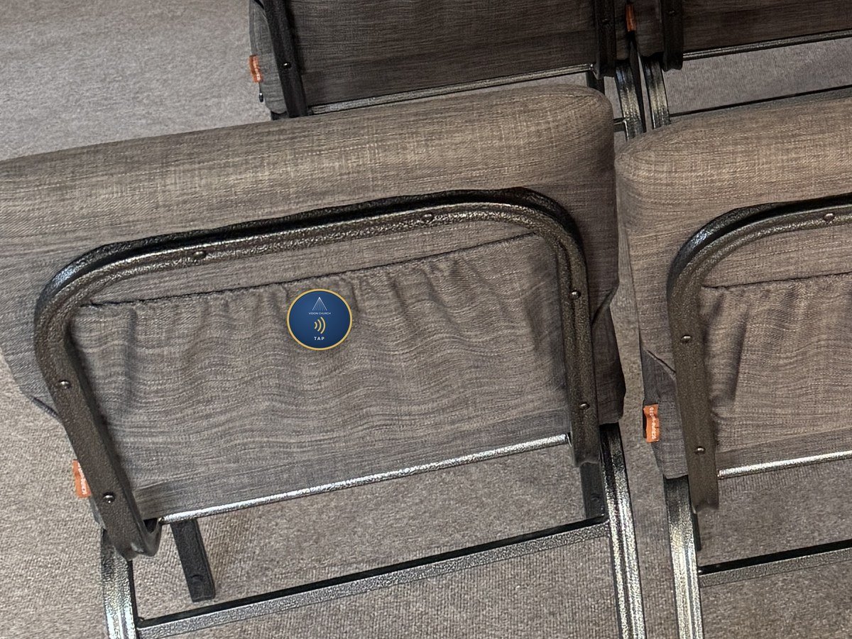 A round Tap Tag in the middle of a chair back at Vision Church